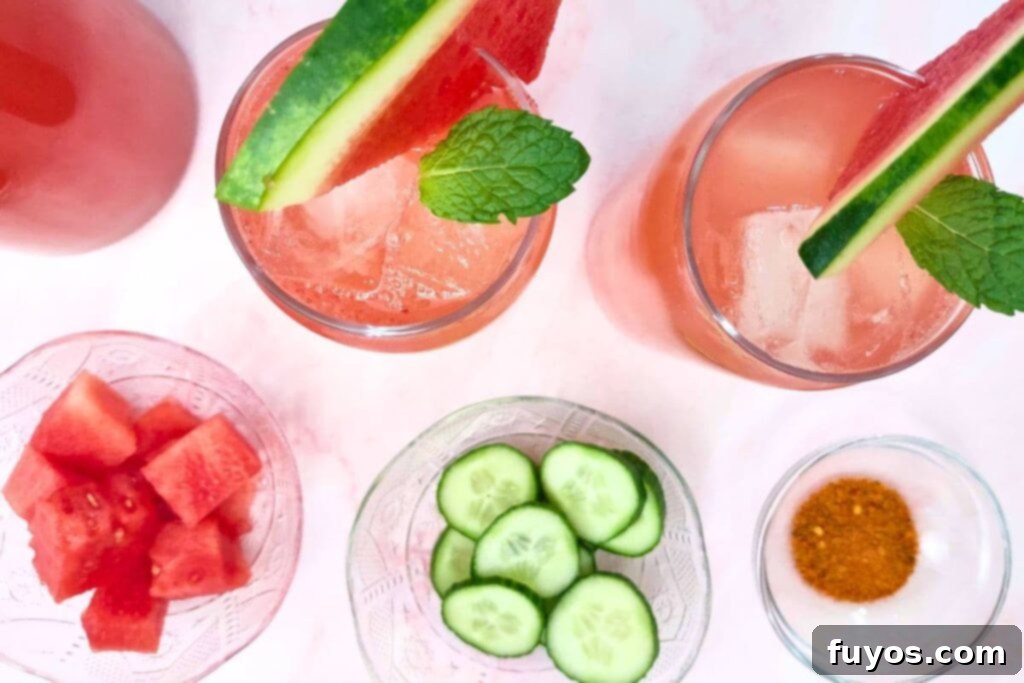 overhead view of two glasses of watermelon cucumber agua fresca with fresh fruits and vegetables