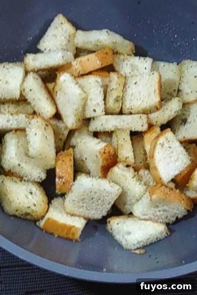Crispy Herb Garlic Croutons Made in Your Air Fryer 5 toss bread cubes in mixing bowl with oil and seasoning