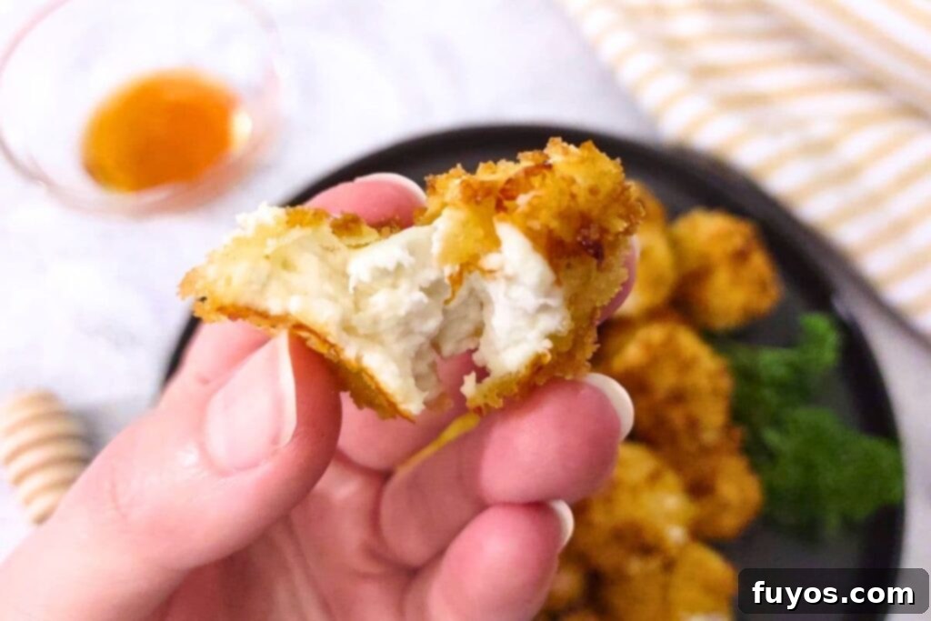 Air Fryer Goat Cheese Balls Crunchy Creamy Delight 3 A gooey air fryer goat cheese ball split in half, showing the warm, melted interior.