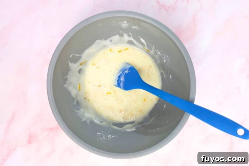 Mixing powdered sugar and orange juice in a small bowl to create the glaze