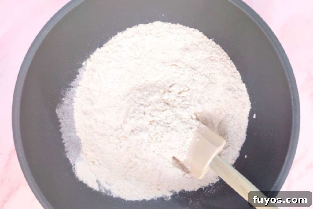 Mixing flour, baking powder, sugar, and salt in a large bowl for scone dough