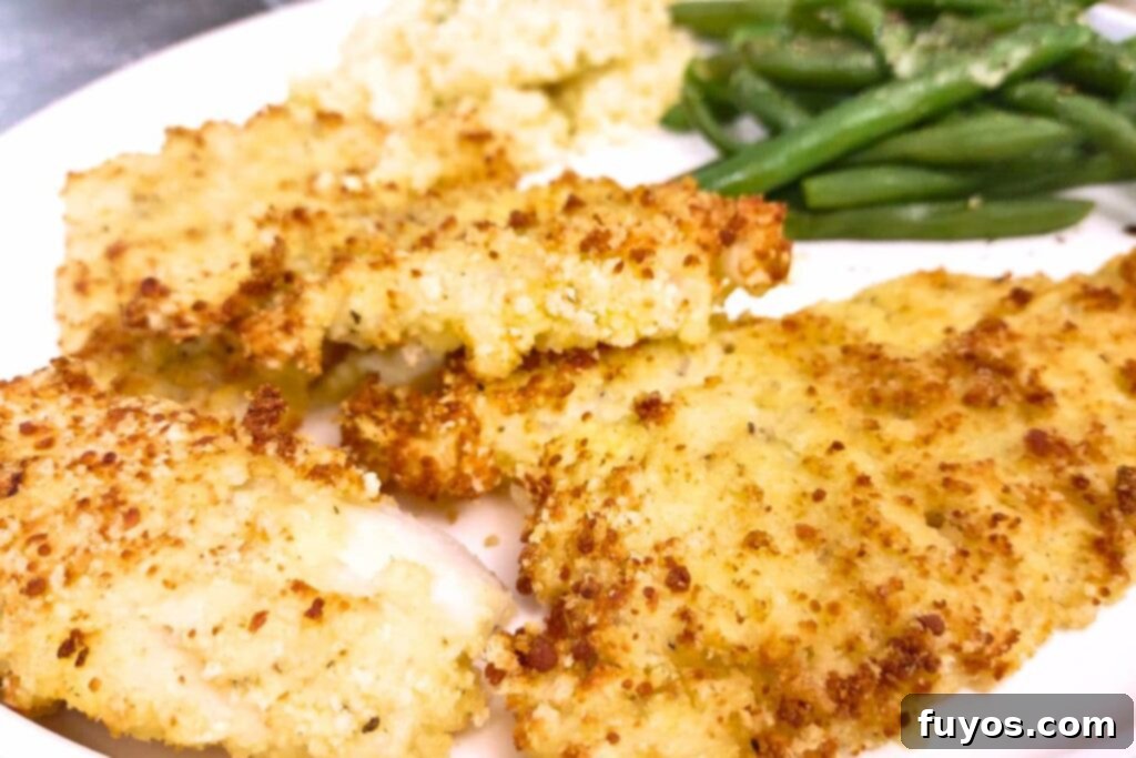 Air Fryer Crispy Parmesan Cod 12 closeup of parmesan crusted cod on a plate with green beans
