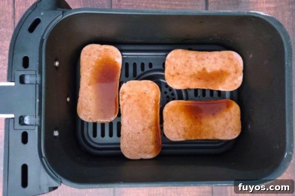 Air Fryer Spam Musubi Your Homegrown Hawaiian Treat 7 brush spam slices with teriyaki sauce in air fryer basket
