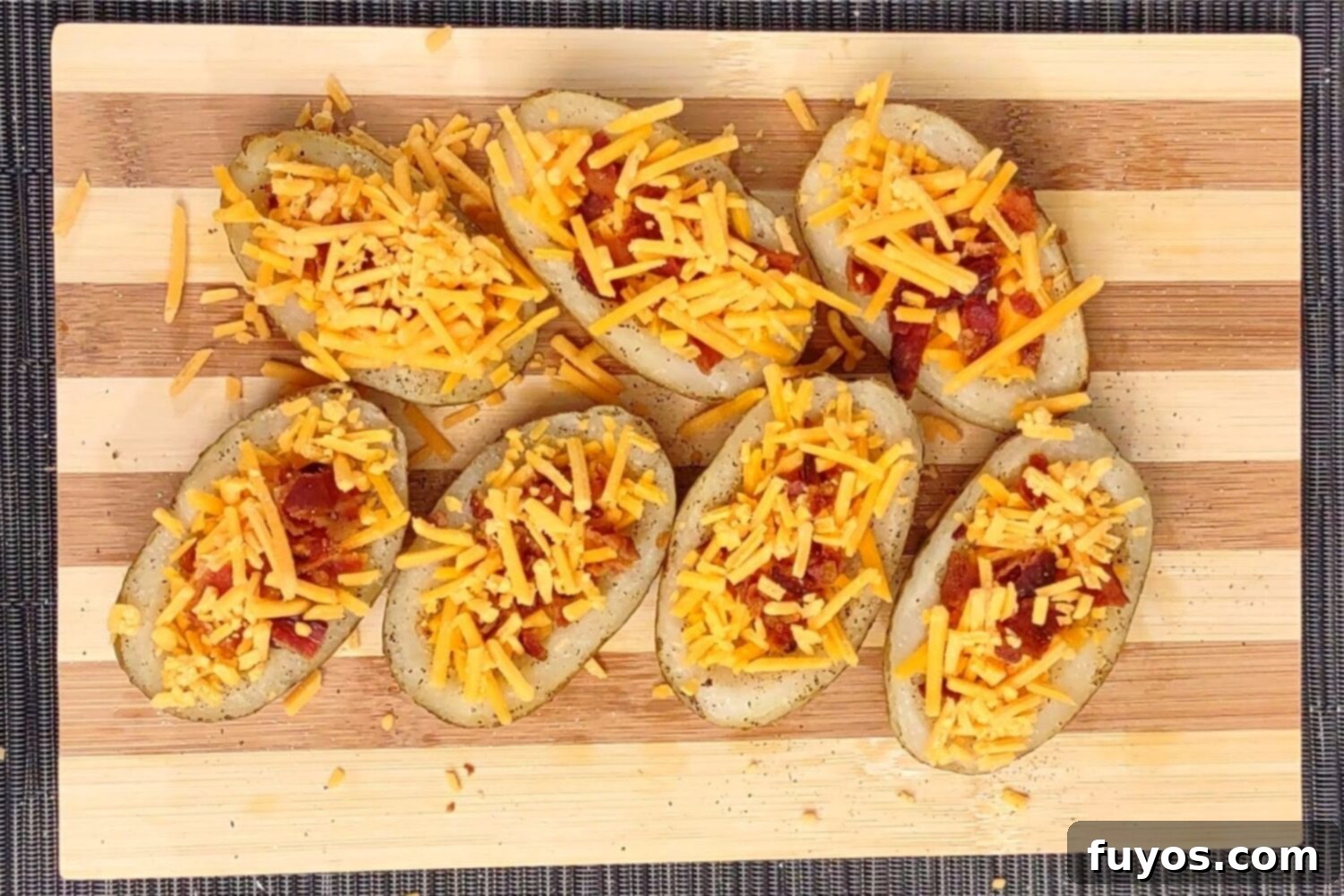 The Best Air Fryer Potato Skins 7 Adding shredded cheddar cheese and crumbled bacon to potato skins