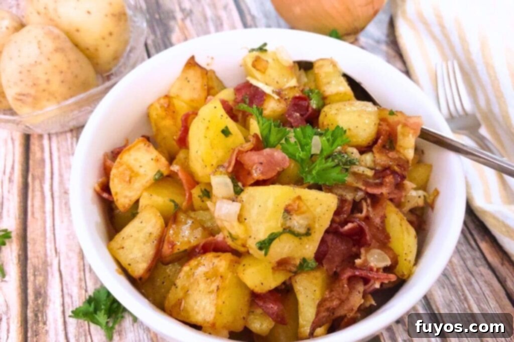 Delicious and easy air fryer German potato salad served in a white bowl, garnished with fresh parsley.