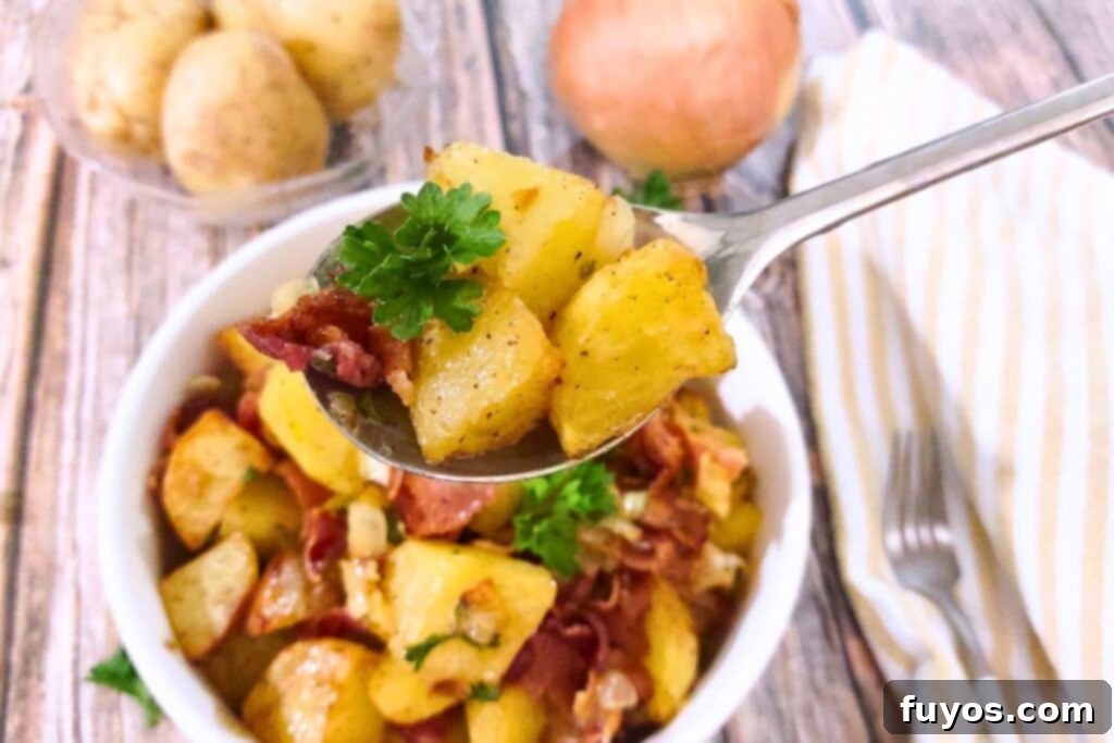 Spoonful of warm, tangy air fryer German potato salad with bacon