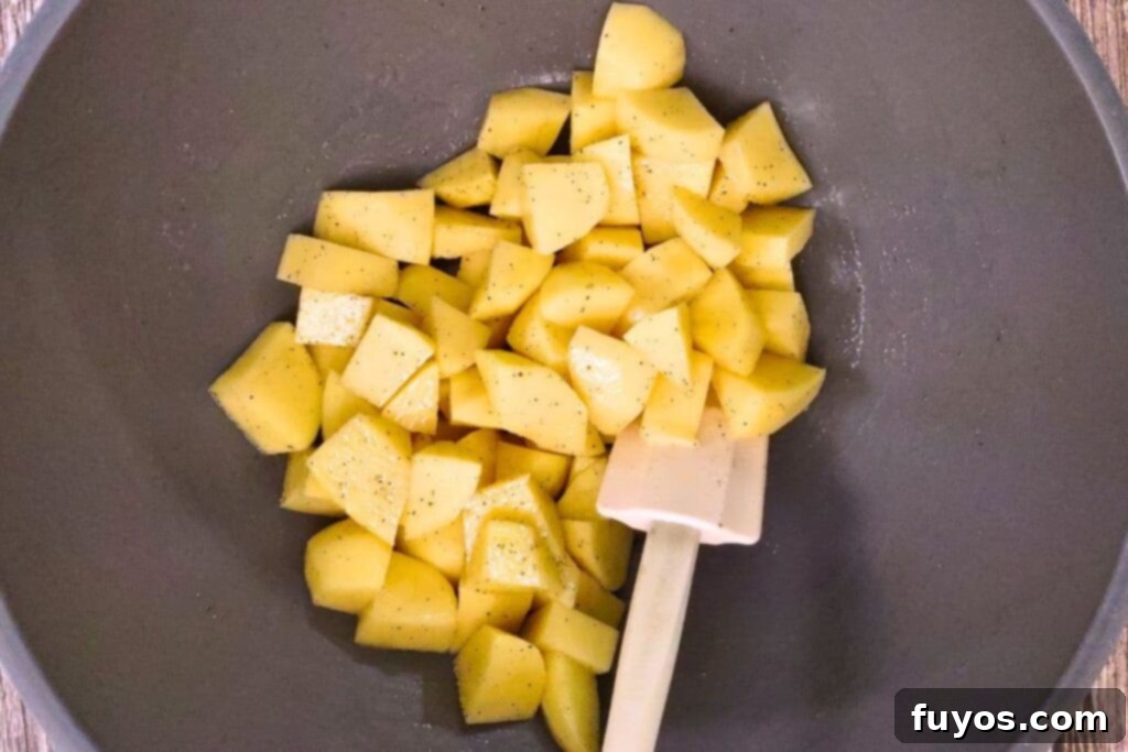 Toss potato cubes in olive oil, salt, and pepper in a bowl