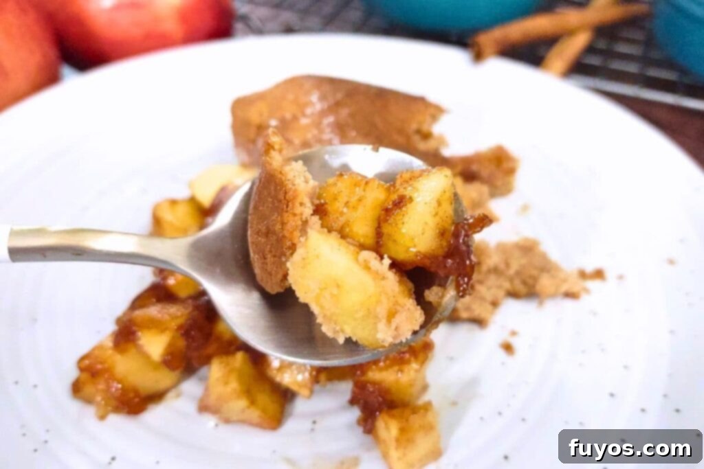Easy Air Fryer Apple Cobbler Recipe Sweet Autumn Delight 3 holding up a spoonful of air fryer apple cobbler