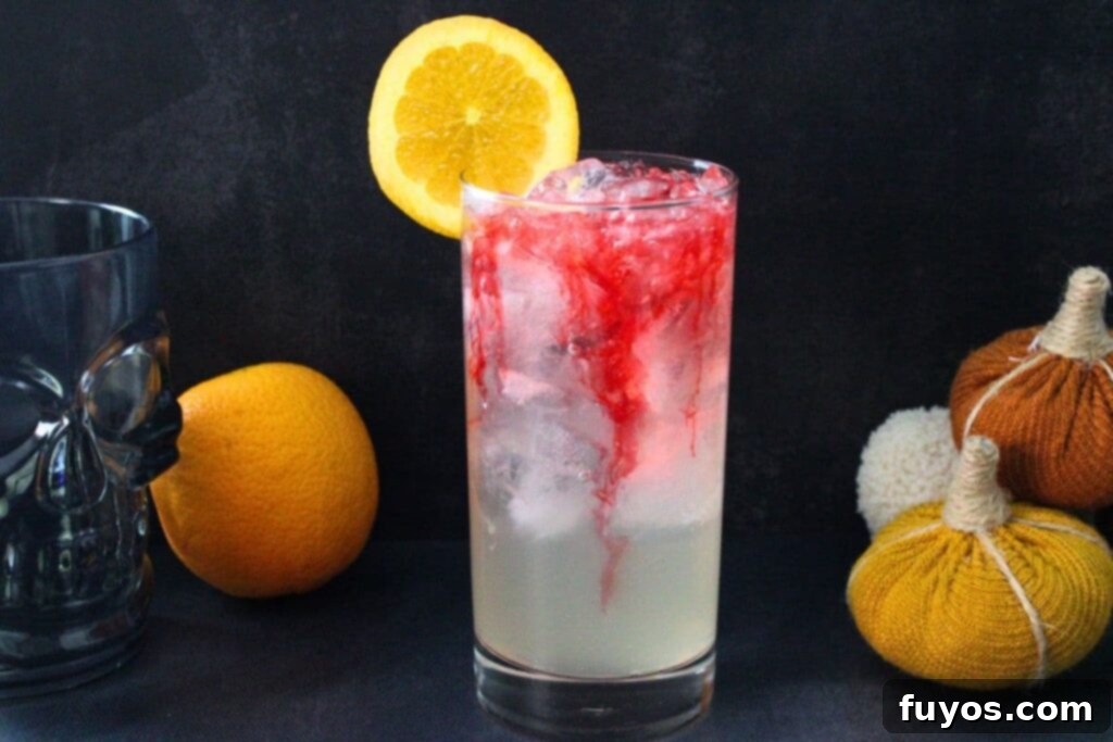 A Headless Horseman cocktail with red bitters slowly oozing down into the drink, showcasing the visual effect.