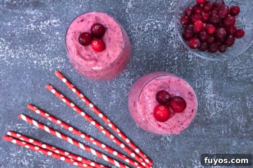 overhead view of two cranberry banana smoothies with striped straws
