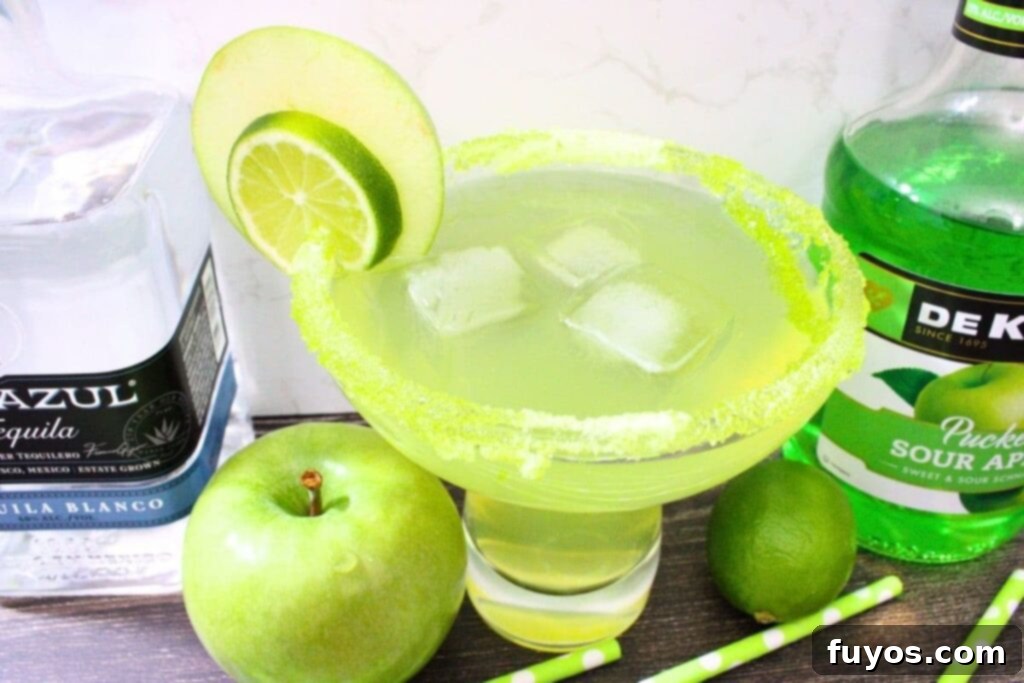 Sweet and Tart Green Apple Margarita Bliss 10 large sour green apple margarita with fruit garnish and liquor bottles
