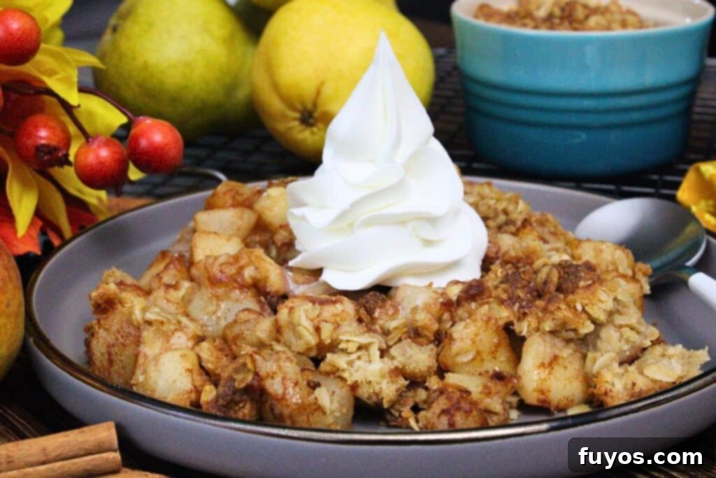 20-Minute Air Fryer Pear Crisp for Fall 3 side view of an air fryer pear crisp topped with a dollop of whipped cream