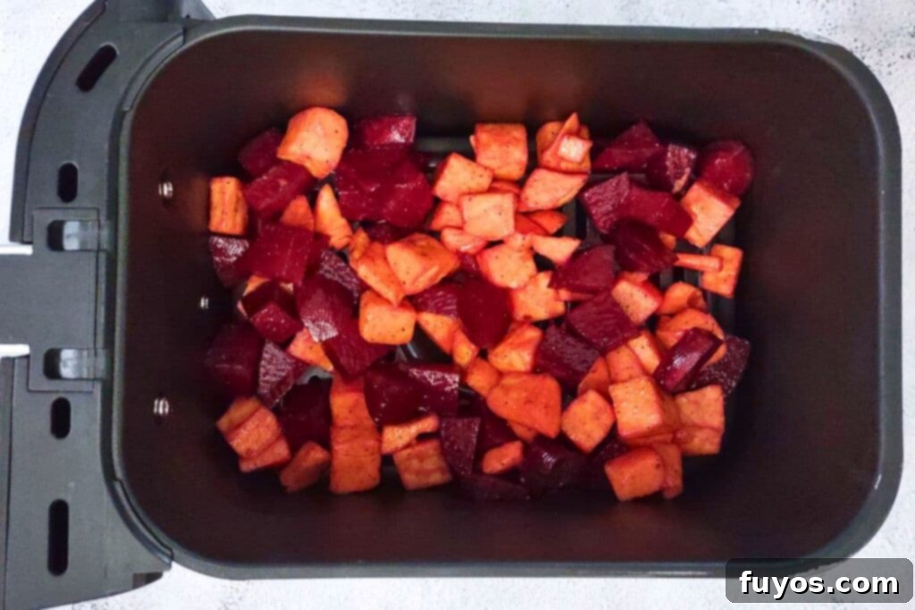 spread beets and sweet potatoes in a layer across the air fryer basket
