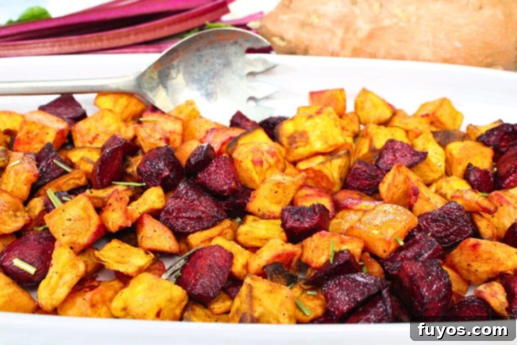 colorful air fryer beets and sweet potatoes on a platter with a serving spoon