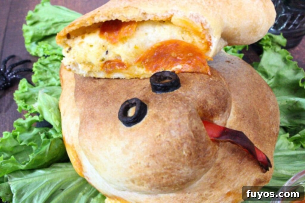 Air Fryer Serpent Bites: Your Halloween Party Hit 3 snake calzone facing you with a slice of pepperoni and ricotta filling visible