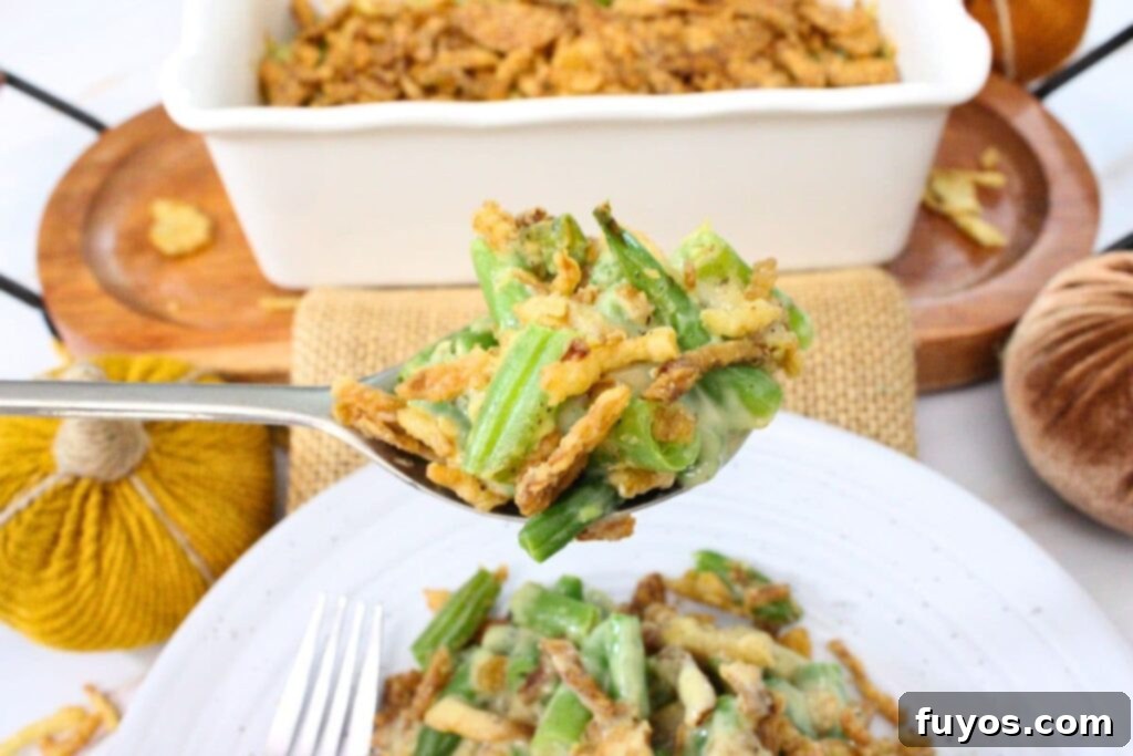 A spoonful of creamy air fryer green bean casserole with crispy onions