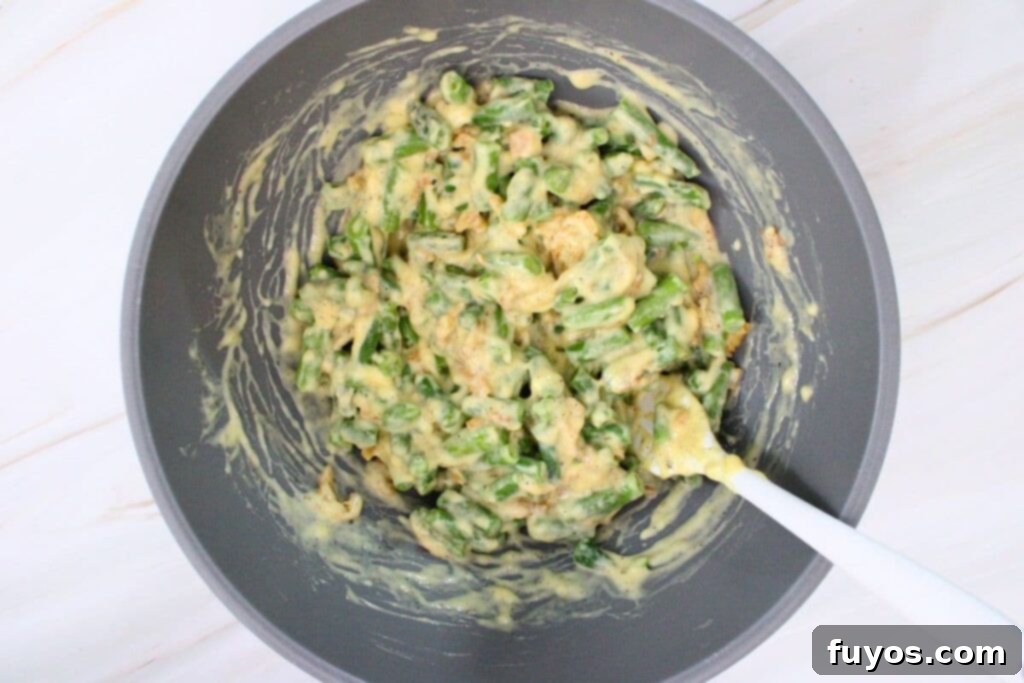 Combining green beans, soup, milk, seasonings, and onions in a mixing bowl