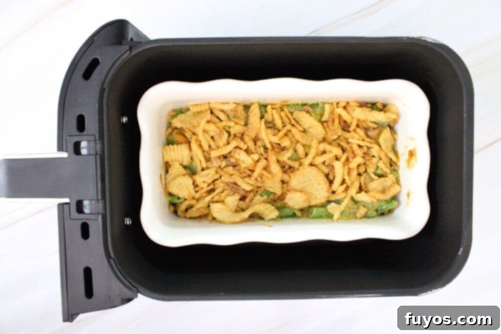 Topping the green bean casserole with remaining crispy fried onions