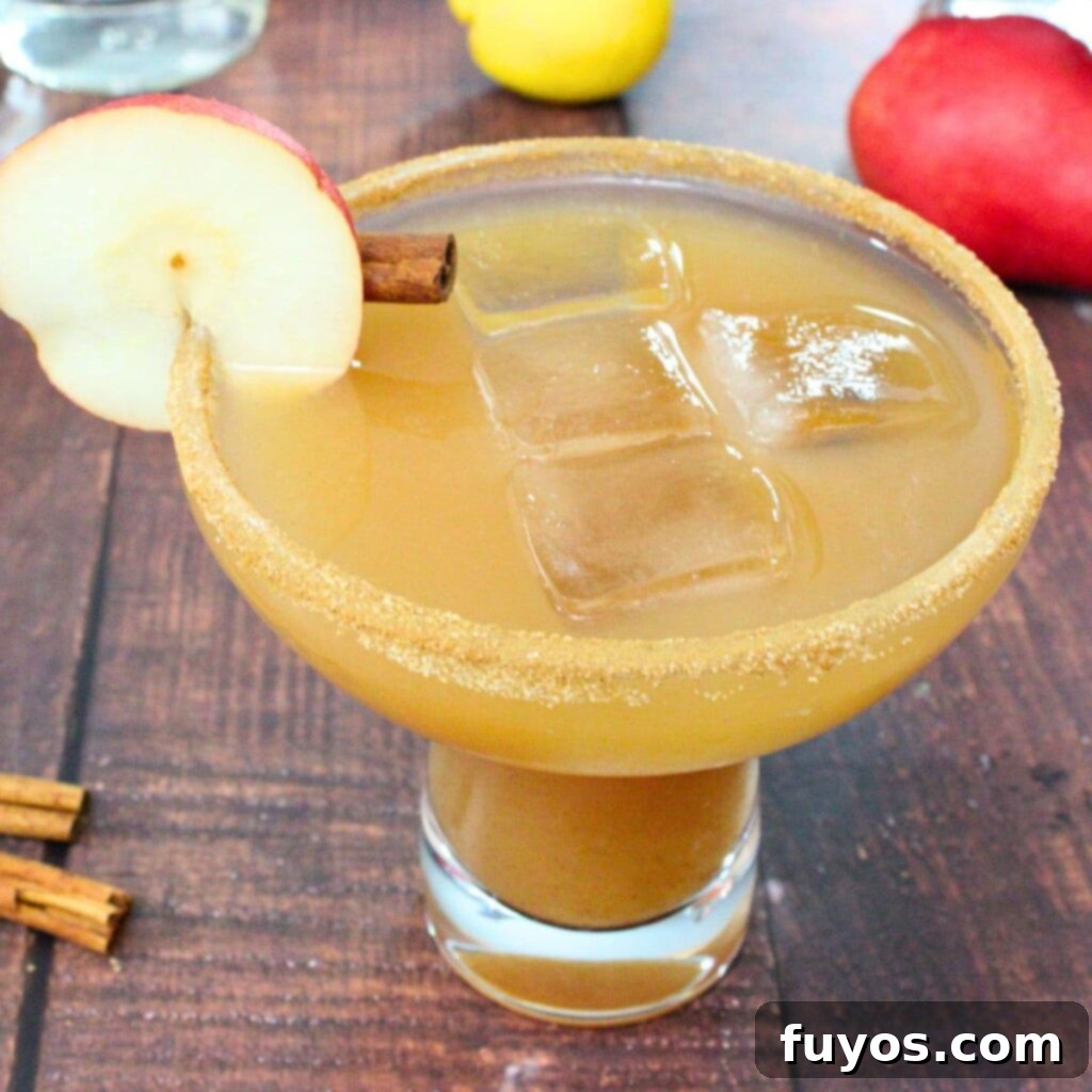 Spiced pear margarita cocktail recipe, a delightful fall drink featuring tequila, pear syrup, lemon, and cinnamon, garnished with a pear slice and cinnamon stick.