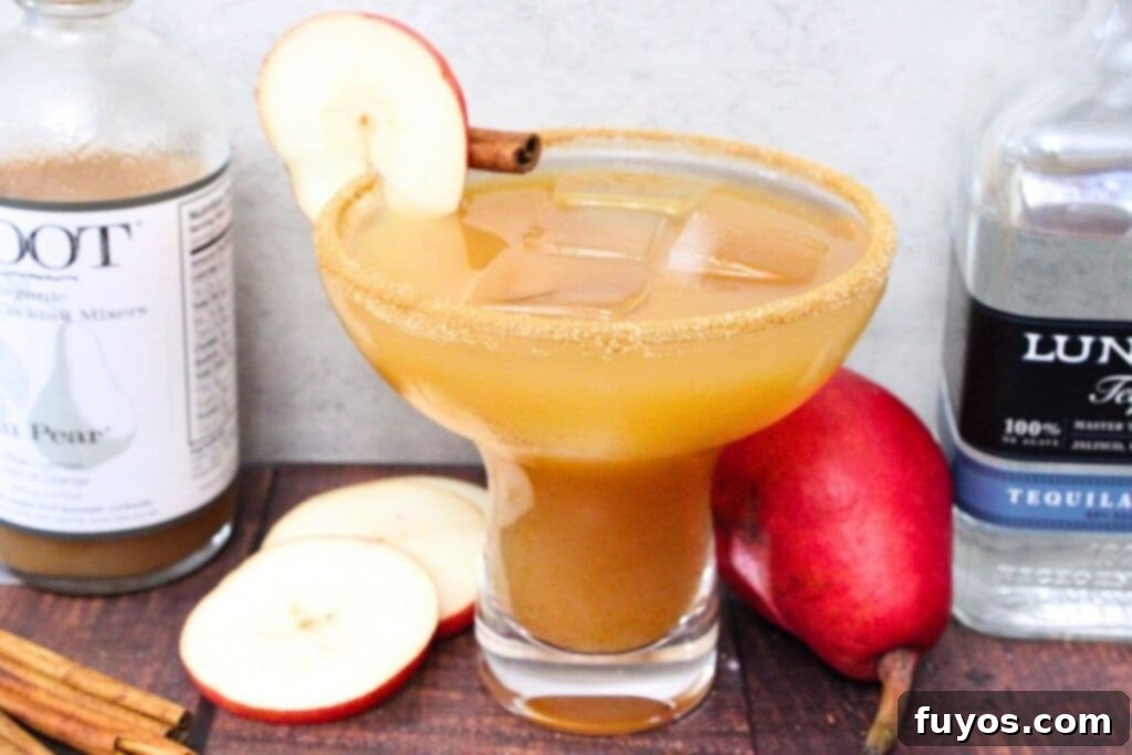 Spiced pear margarita cocktail served in a glass, surrounded by bottles of tequila, triple sec, pear syrup, fresh lemons, and cinnamon sticks, highlighting the key ingredients.