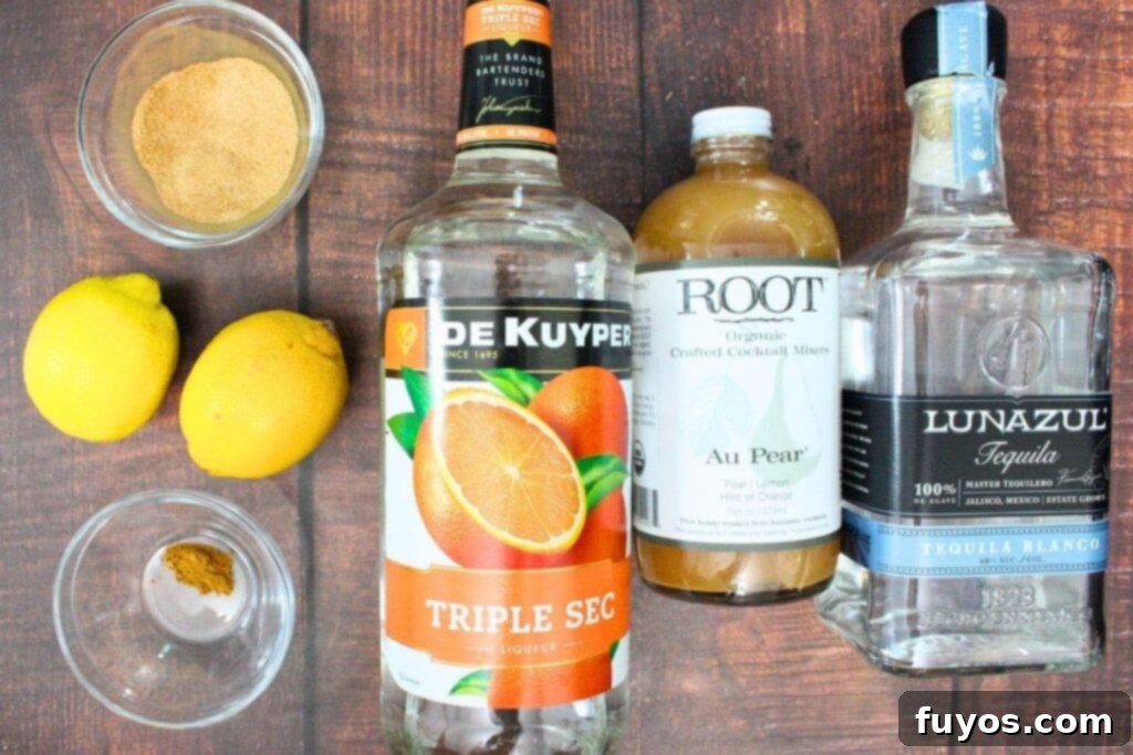 All ingredients laid out for a spiced pear margarita, including tequila, triple sec, pear syrup, fresh lemon, cinnamon, sugar, and ice cubes.