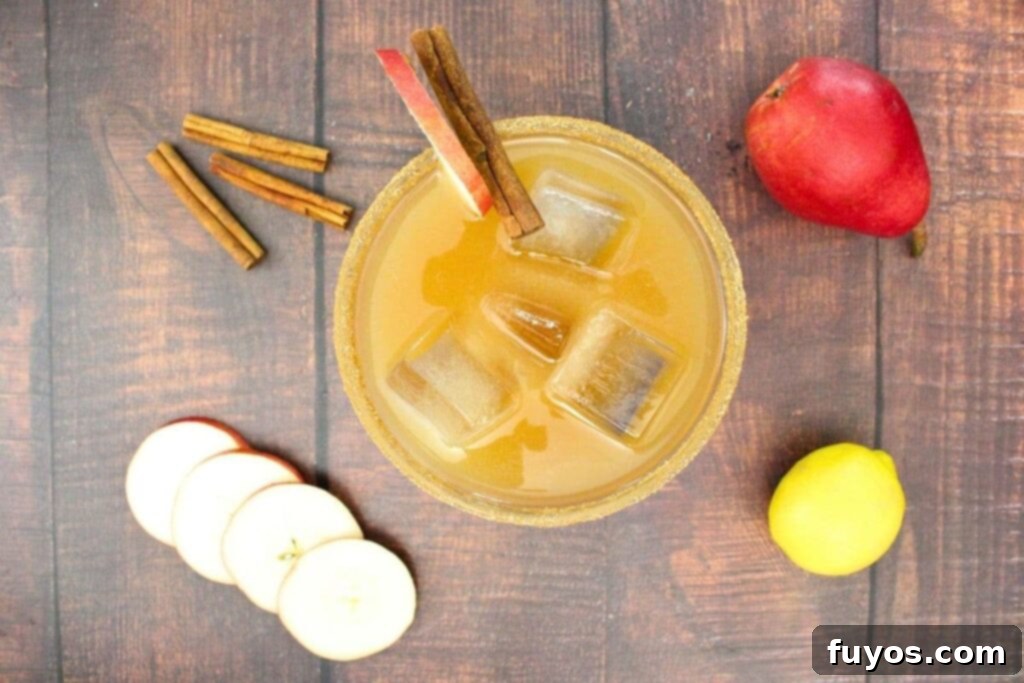 Overhead view of a finished spiced pear margarita, beautifully garnished with cinnamon sticks and delicate pear slices.