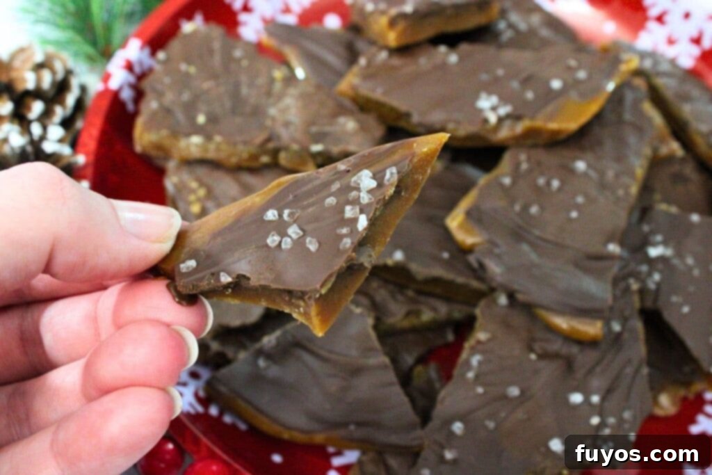 holding up a piece of microwave toffee with sea salt on top