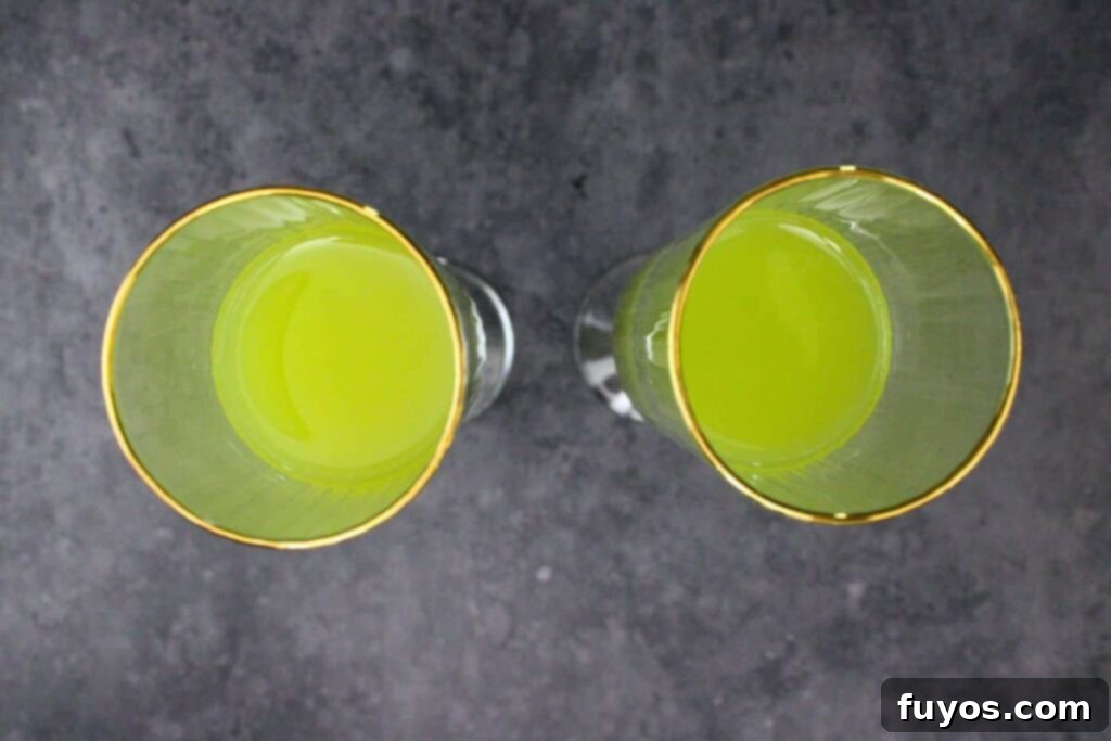 Three Ingredient Grinch Whoville Mimosas 5 add orange juice and hpnotiq vodka to champagne flute