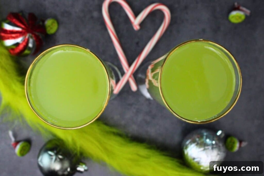 Three Ingredient Grinch Whoville Mimosas 7 overhead view of two grinch mimosas surrounded by heart candy cane