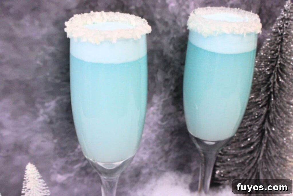 Jack Frost Mimosa Your Sparkling Winter Brunch Delight 3 two jack frost mimosas in champagne flutes against a dark background