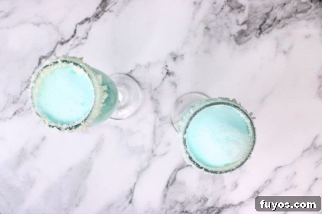 Jack Frost Mimosa Your Sparkling Winter Brunch Delight 8 pour champagne or prosecco over the blue liquor mixture