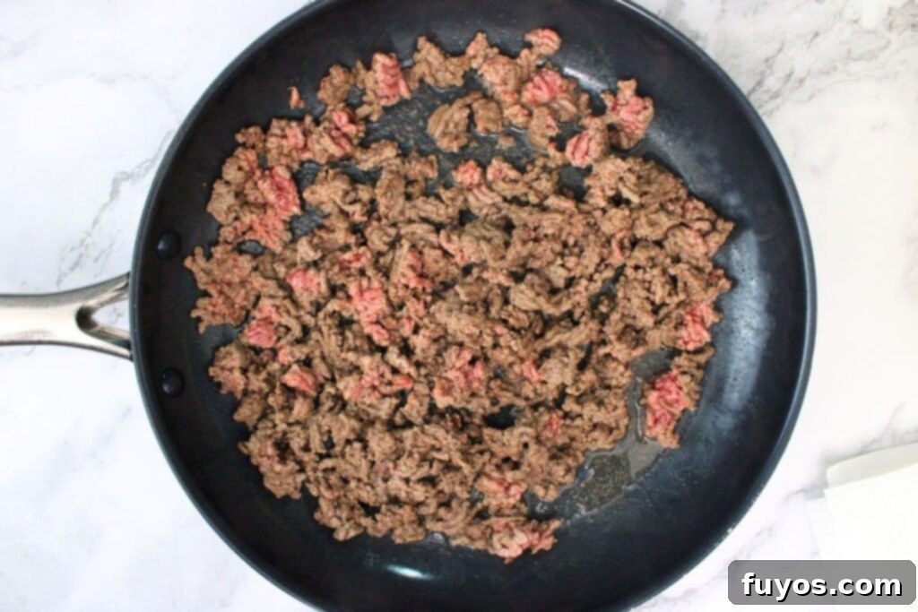 The Ultimate Air Fryer Nachos for Game Day 5 partially brown ground beef in skillet