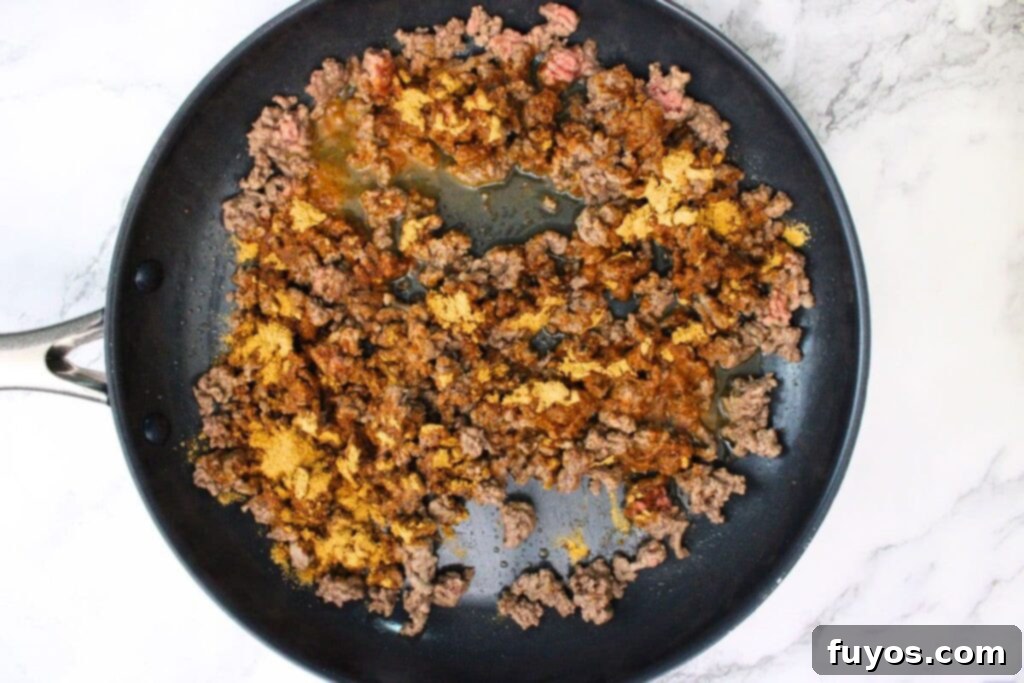 The Ultimate Air Fryer Nachos for Game Day 6 add taco seasoning to the ground beef