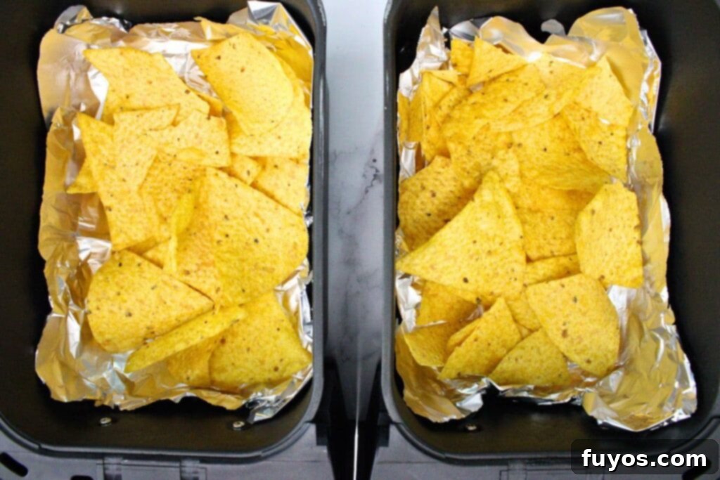 The Ultimate Air Fryer Nachos for Game Day 9 spread half tortilla chips across air fryer basket