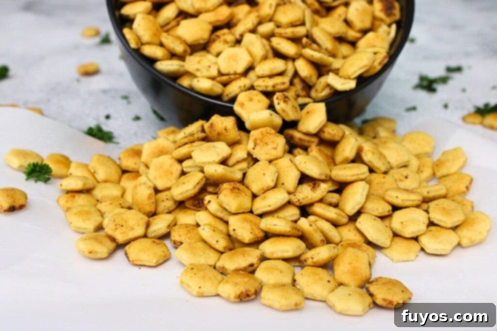 air fryer oyster crackers spilling out of a bowl on to parchment paper