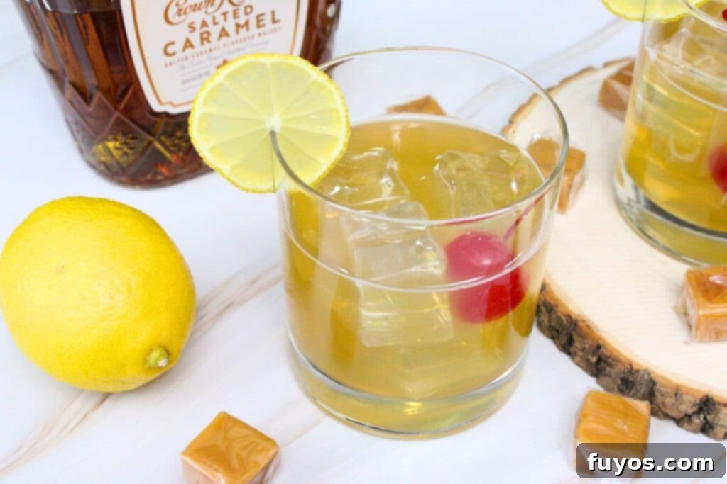 Salted Caramel Whiskey Sour in a glass with a lemon slice, whiskey bottle in background