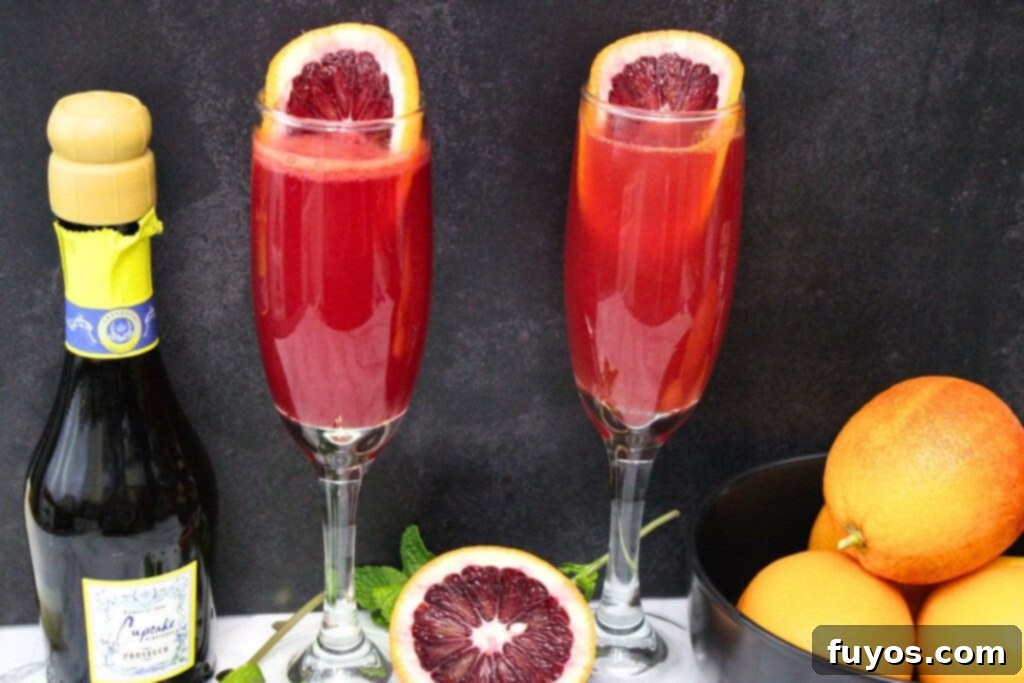 Your Simple 3 Ingredient Blood Orange Mimosa for Winter Brunch 3 blood orange mimosas in champagne flutes with bottle and fresh oranges next to it