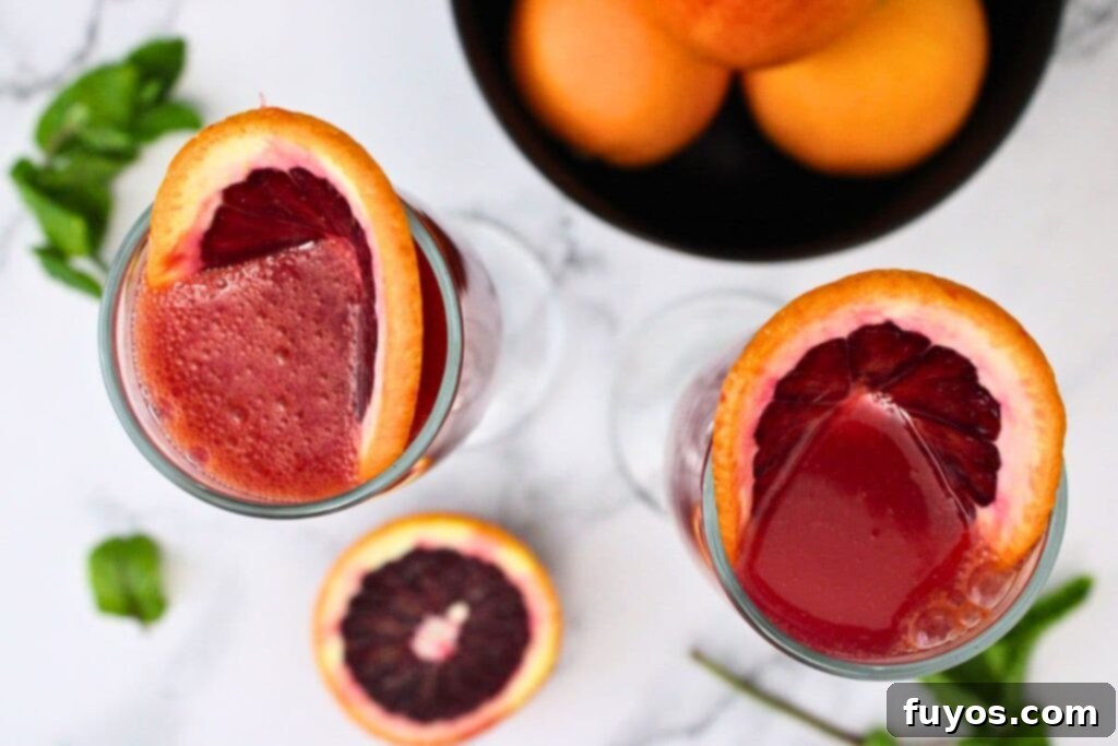 Your Simple 3 Ingredient Blood Orange Mimosa for Winter Brunch 7 overhead view of blood orange mimosas with blood orange slices folded inside