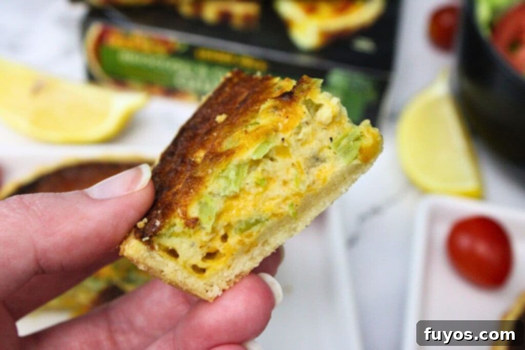 Trader Joe's Frozen Quiche Air Fryer Perfection 3 holding up a slice of trader joes broccoli cheddar quiche