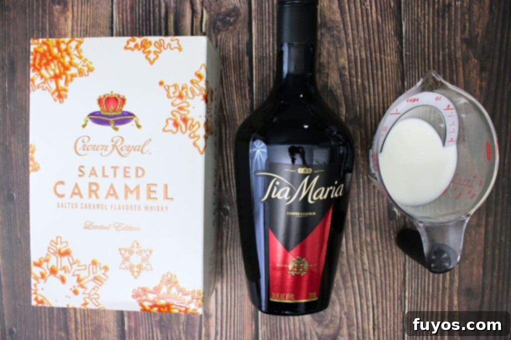 Salted Caramel Royal White Russian Bliss 4 A flat lay of the essential ingredients needed to make a Crown Royal Salted Caramel White Russian: a bottle of Crown Royal Salted Caramel whiskey, coffee liqueur, and a carton of half and half, all surrounded by ice cubes.