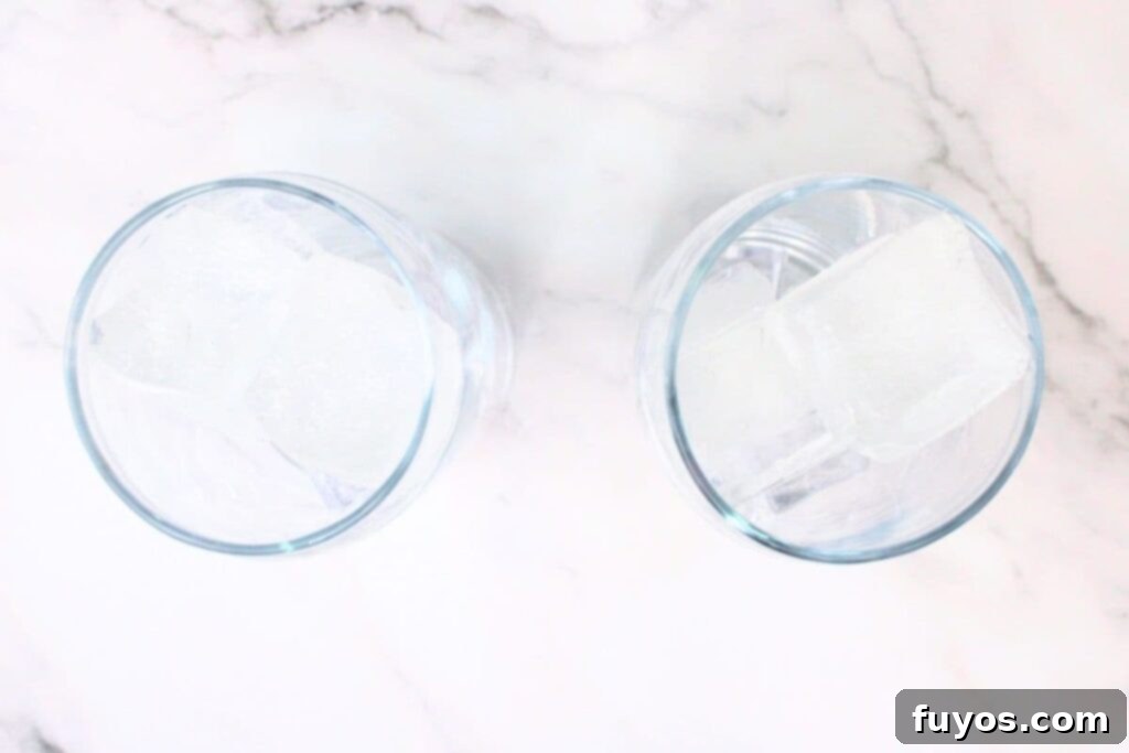 Pink Whitney and Sprite Recipe Easy 2 Ingredient Cocktail 5 A highball glass is filled to the brim with ice cubes, ready for cocktail preparation.
