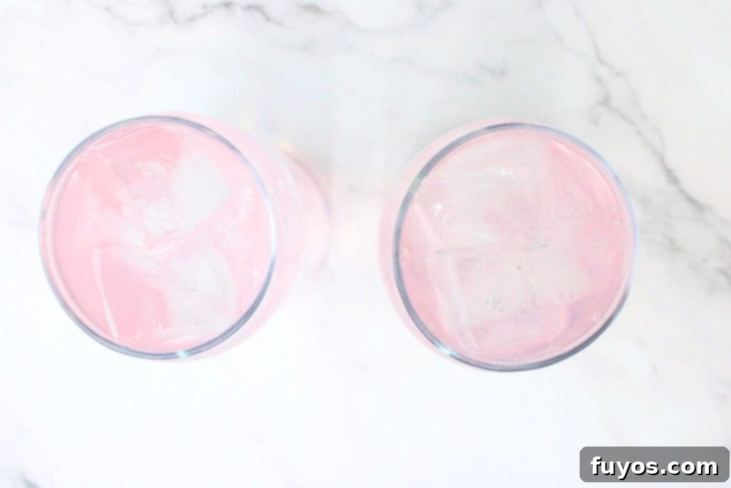 Pink Whitney and Sprite Recipe Easy 2 Ingredient Cocktail 7 Sprite being poured over the Pink Whitney vodka and ice, creating a bubbly, refreshing effect.
