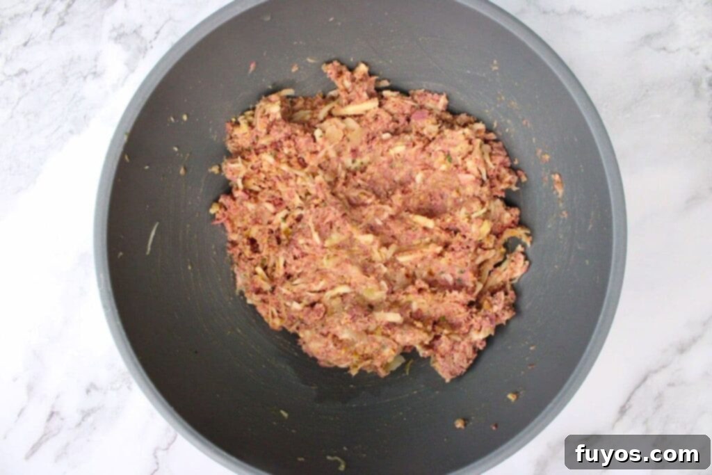 combine corned beef, shredded swiss cheese, rye breadcrumbs, sauerkraut, eggs, and seasoning in a mixing bowl