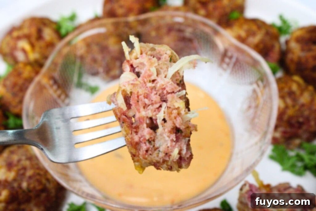holding up half of an air fryer reuben meatball on a fork
