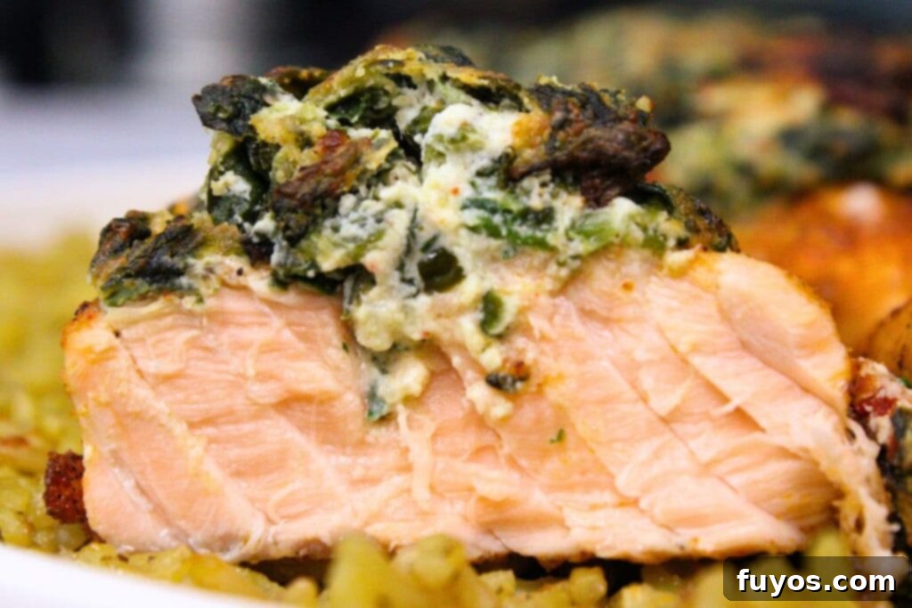 Close-up view of a perfectly cooked slice of air fryer spinach stuffed salmon, showing the creamy filling