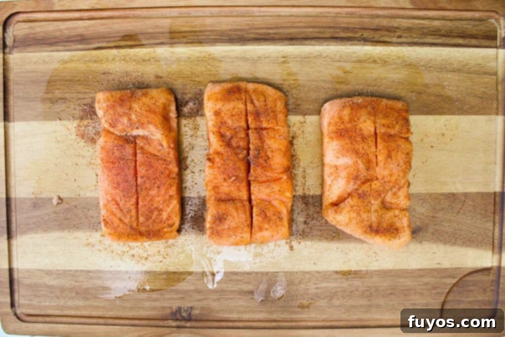 Rubbing salmon fillets with olive oil and then seasoning them with salt, pepper, onion powder, and paprika