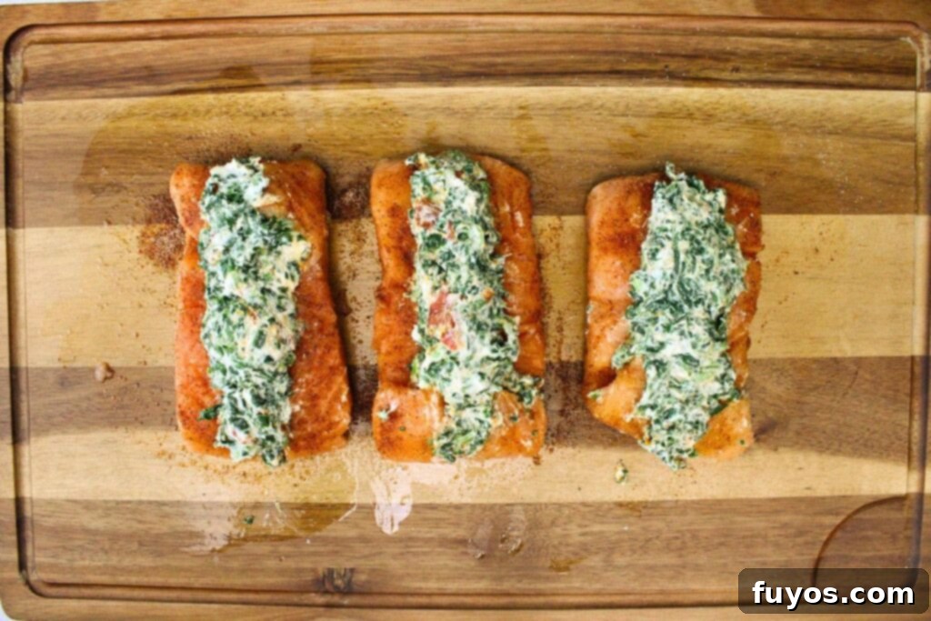 Placing the creamy spinach and Boursin cheese mixture into the slices of the salmon fillets