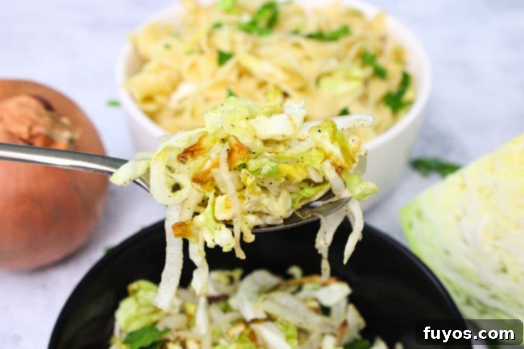 Easy 15-Minute Air Fryer Cabbage and Onions 3 holding up a spoonful of air fryer cabbage and onions