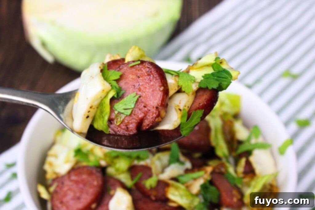 holding up a spoonful of air fryer cabbage and sausage