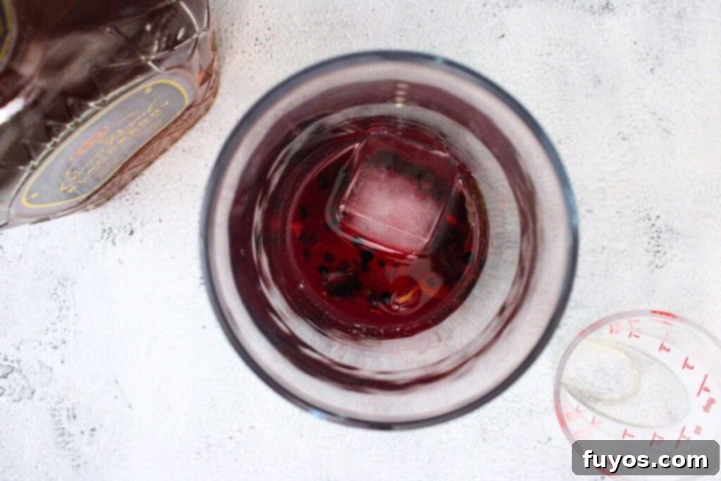 add crown blackberry whiskey and simple syrup to the muddled fruit